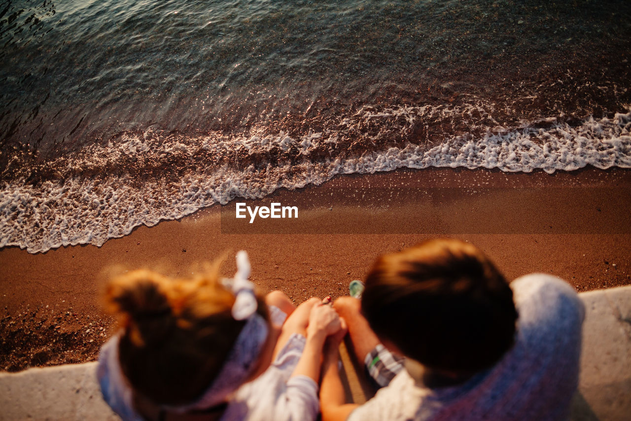 High angle view of couple sitting over sea