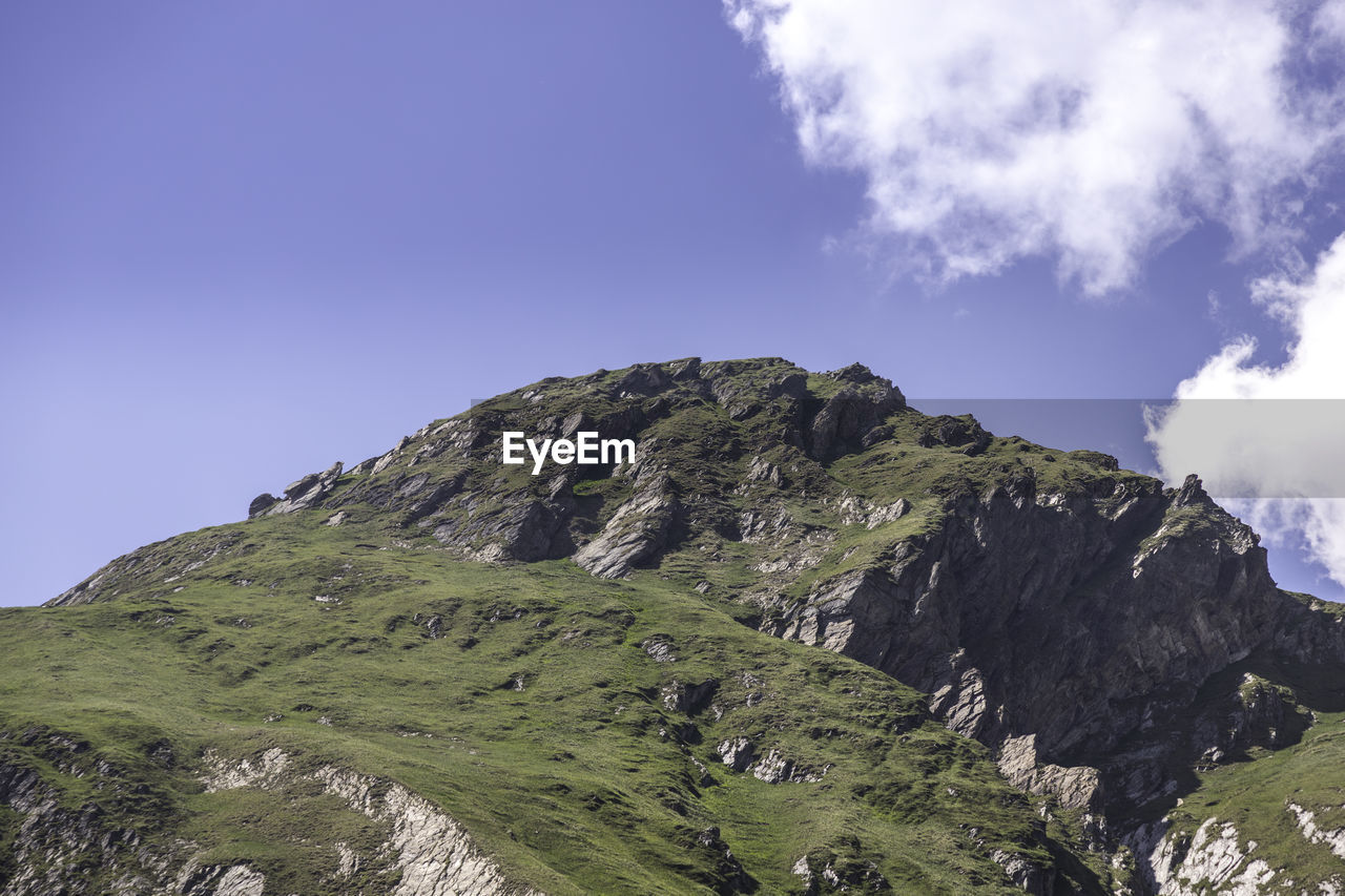 Low angle view of mountain against blue sky