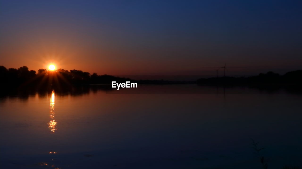 SCENIC VIEW OF LAKE AGAINST ORANGE SKY