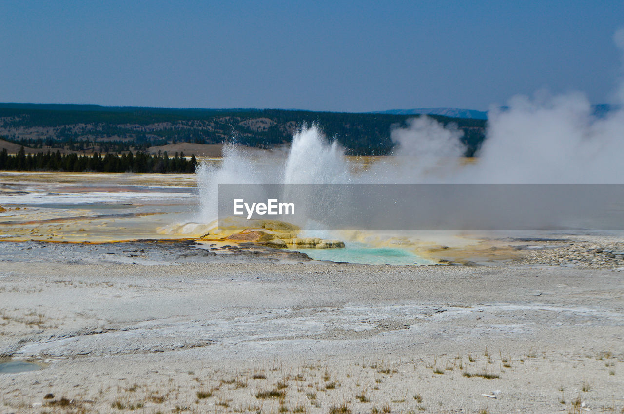 Scenic view of geyser against sky