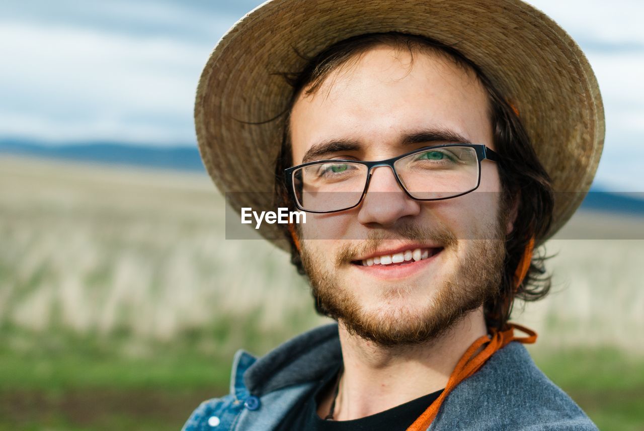 Close-up portrait of smiling young man wearing hat