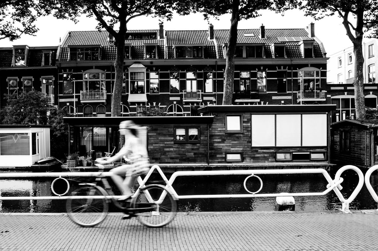 Young woman riding bike on promenade