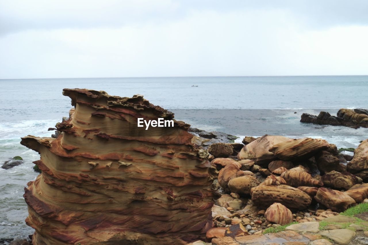 ROCKS ON BEACH AGAINST SKY