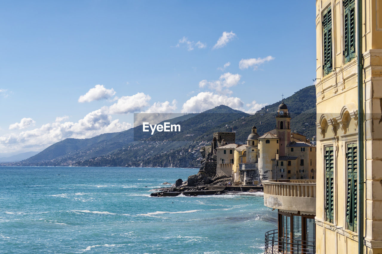 buildings by sea against sky