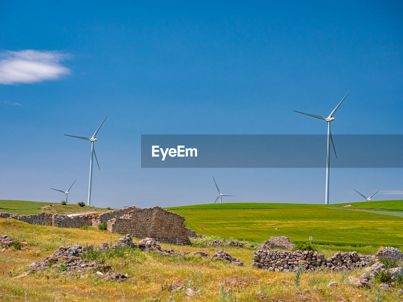 WIND TURBINES ON FIELD AGAINST SKY