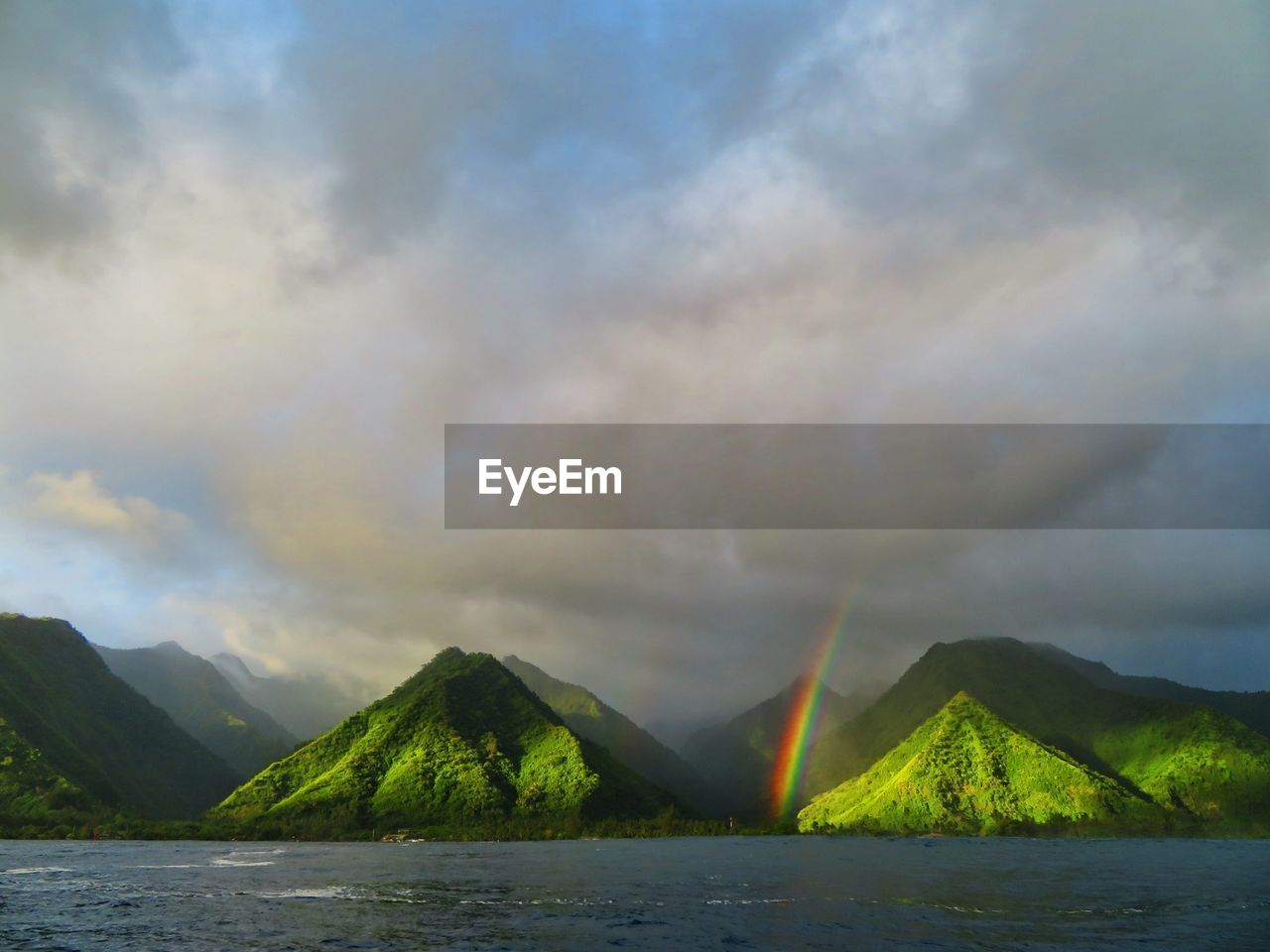 Scenic view of rainbow over mountains against sky