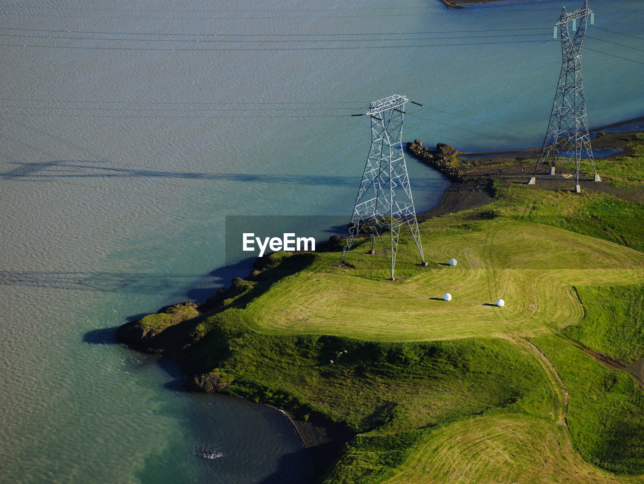 Aerial image of high voltage poles at a glacier river in iceland