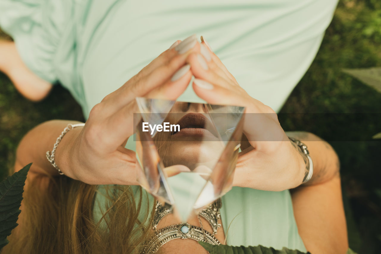 Midsection of woman holding crystal pyramid