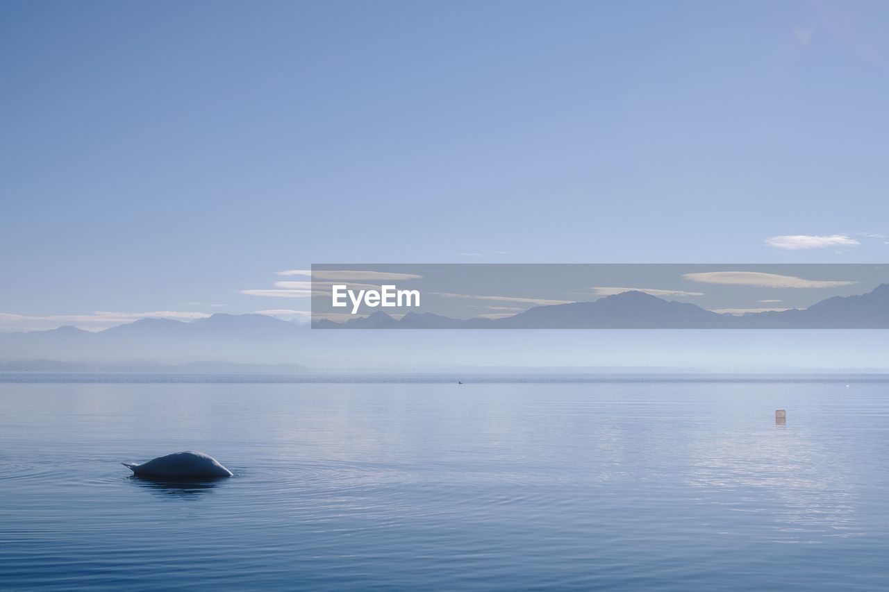 SCENIC VIEW OF SEA BY MOUNTAIN AGAINST BLUE SKY