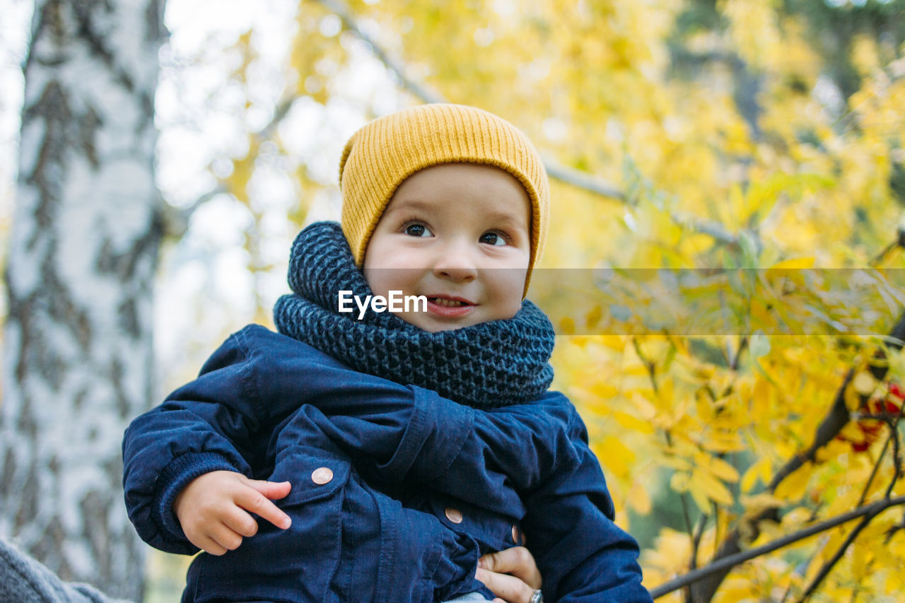 Portrait of cute baby boy against tree