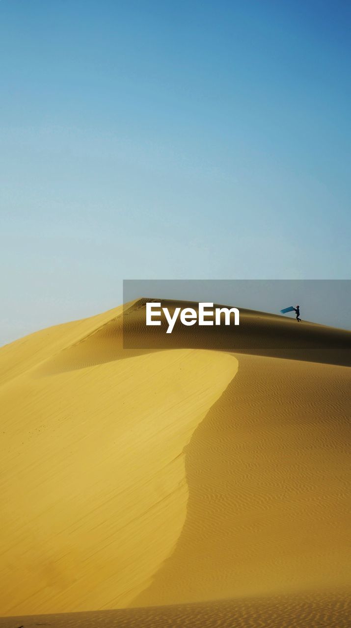 SAND DUNES AGAINST CLEAR SKY