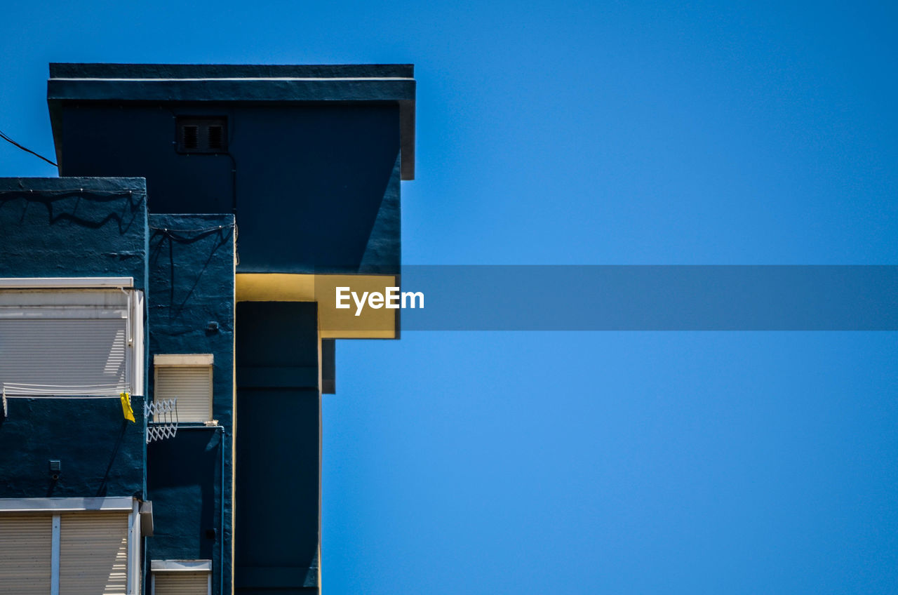 LOW ANGLE VIEW OF BUILDING AGAINST BLUE SKY