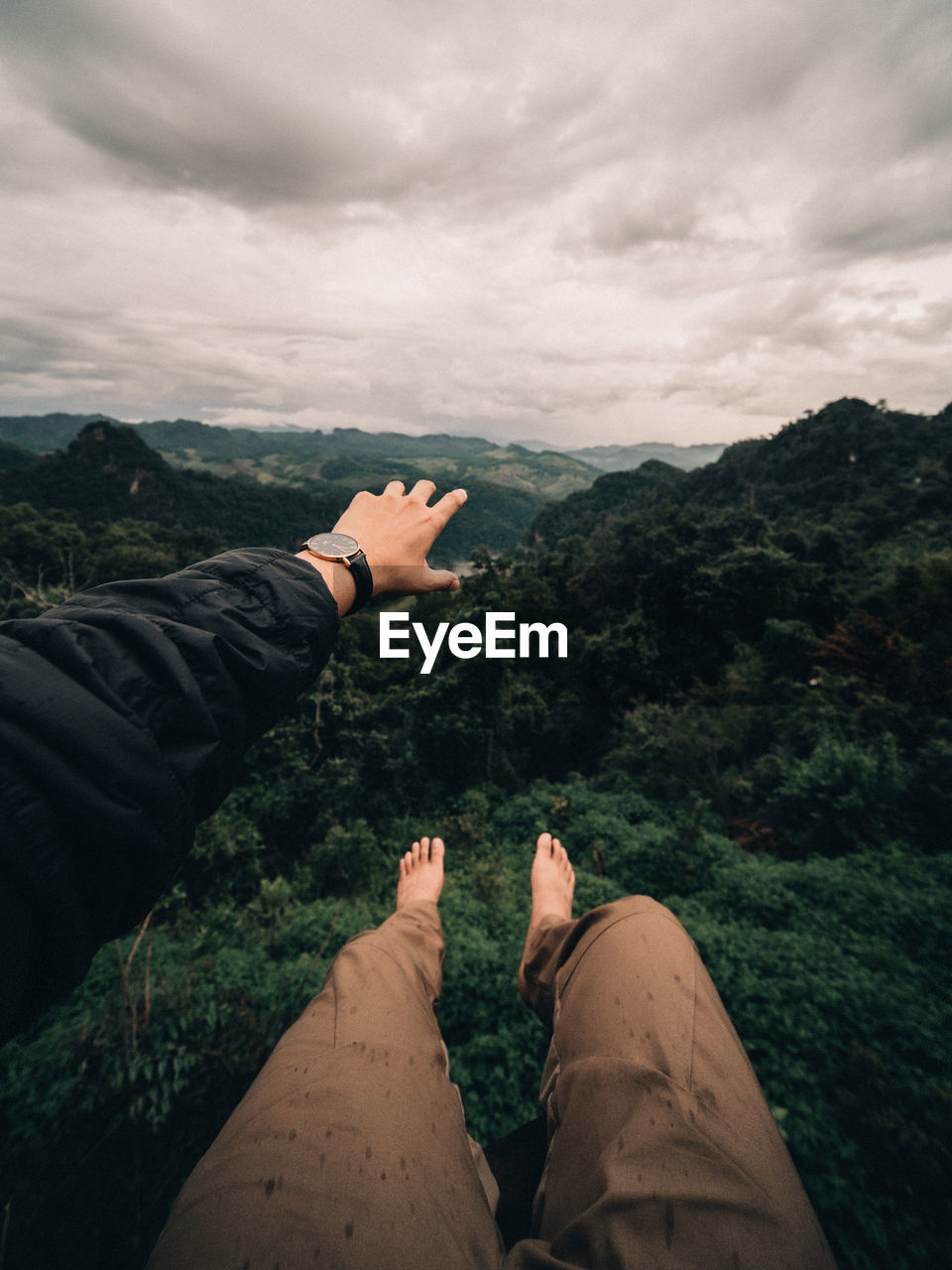 Low section of people on mountain against sky