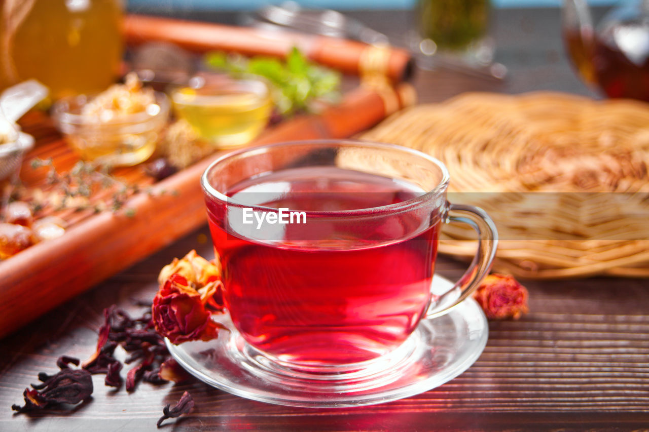 Cup of herbal red tea with dry roses hibiscus