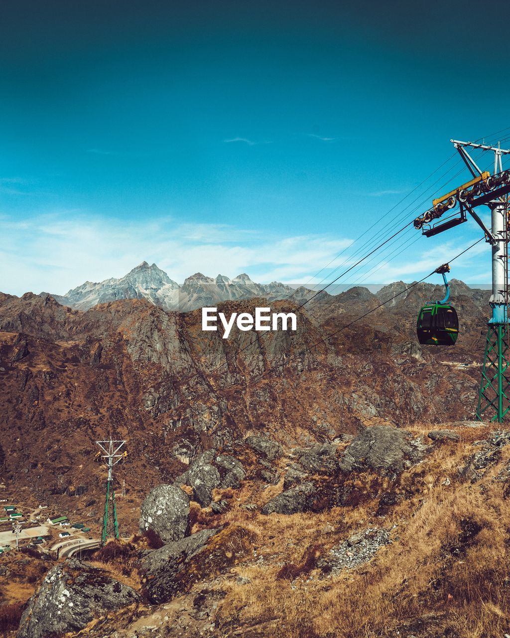 Overhead cable car over mountains against sky