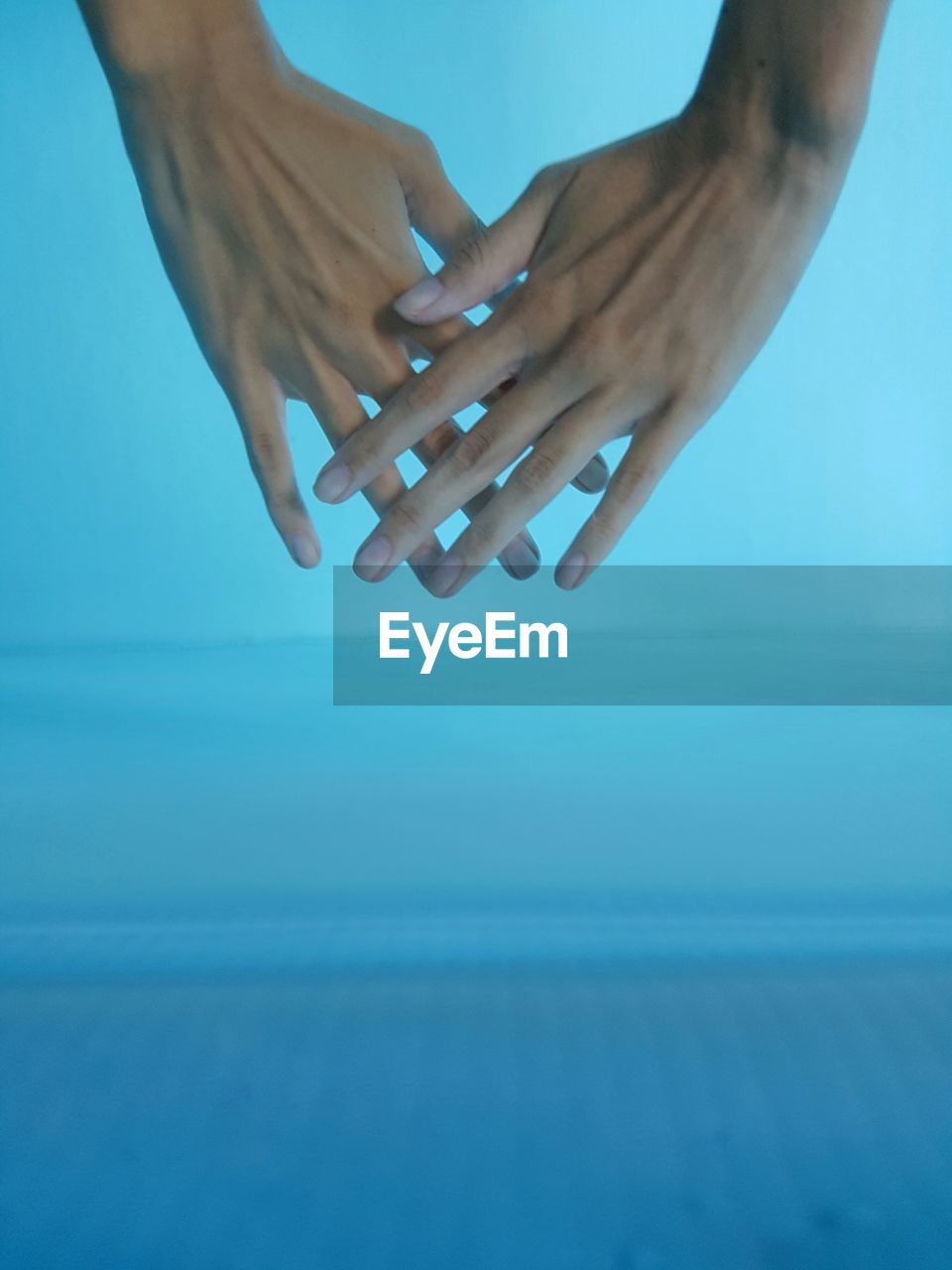 Cropped image of hands in swimming pool