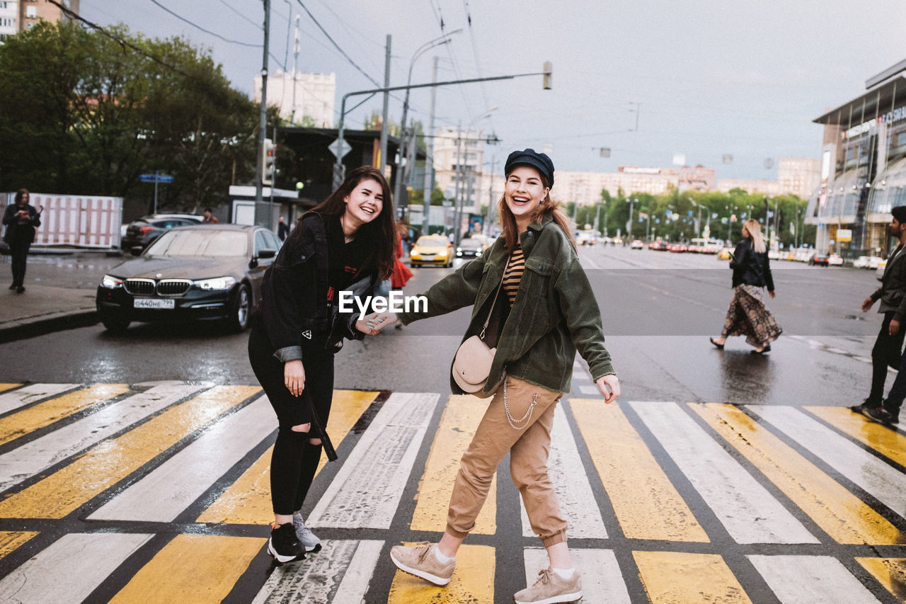 Smiling friends on road in city