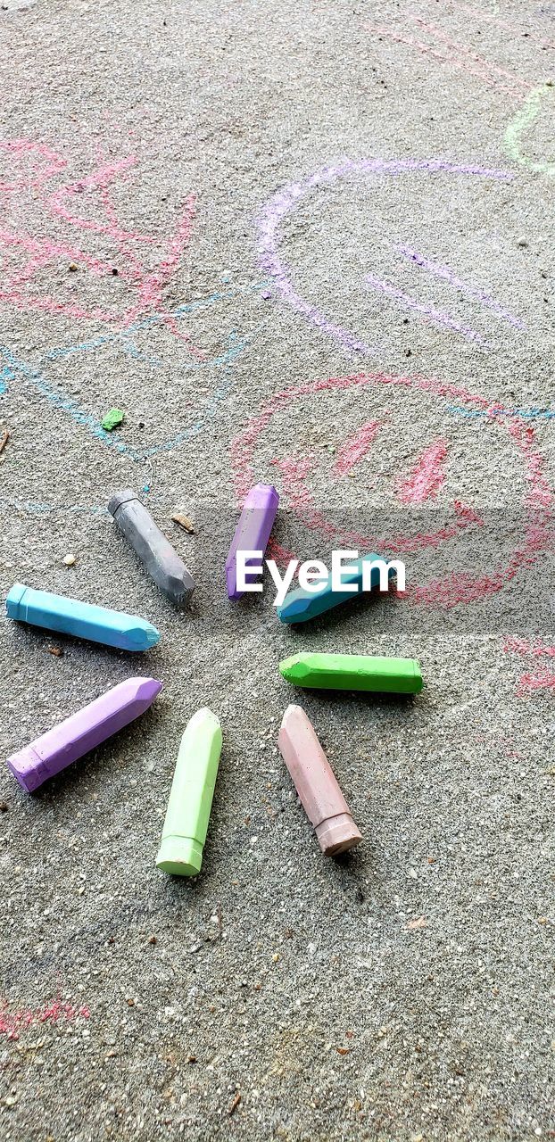 High angle view of multi colored crayons on street