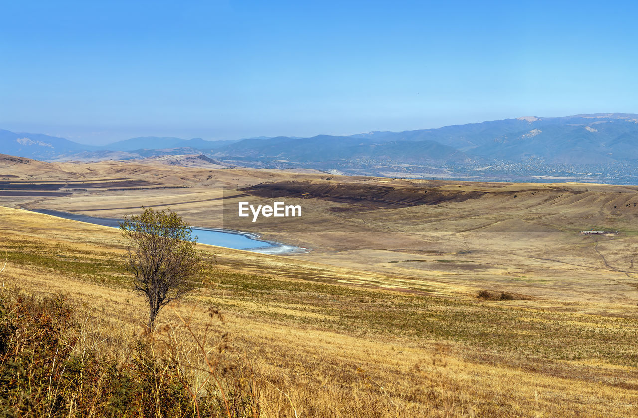 SCENIC VIEW OF LANDSCAPE AND MOUNTAINS AGAINST SKY