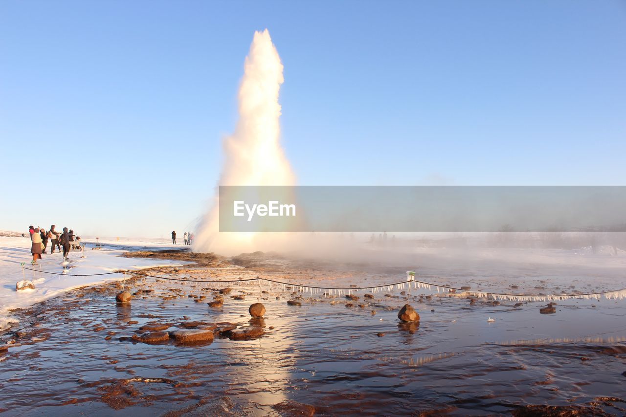 Geyser erupting against clear sky