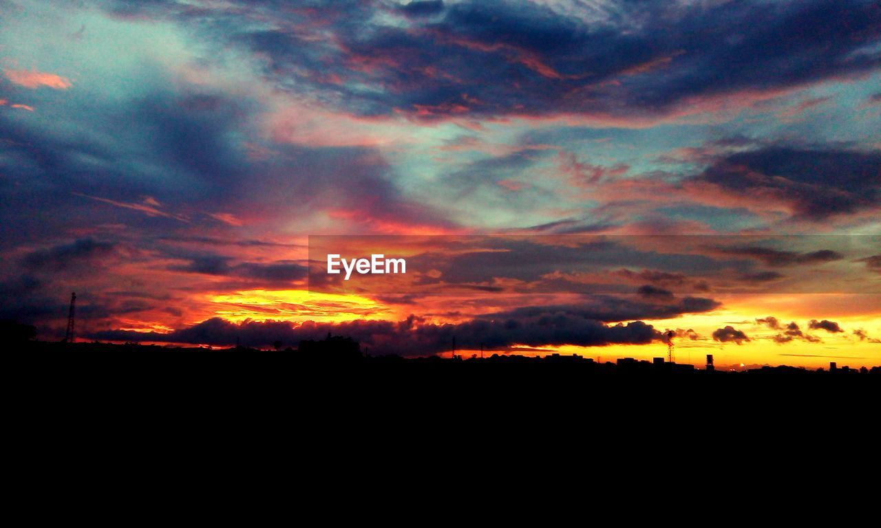 Silhouette of landscape against cloudy sky