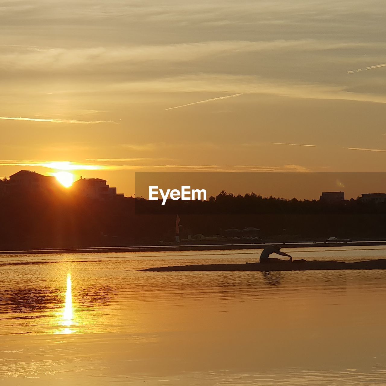 SILHOUETTE PERSON ON SHORE AGAINST ORANGE SKY