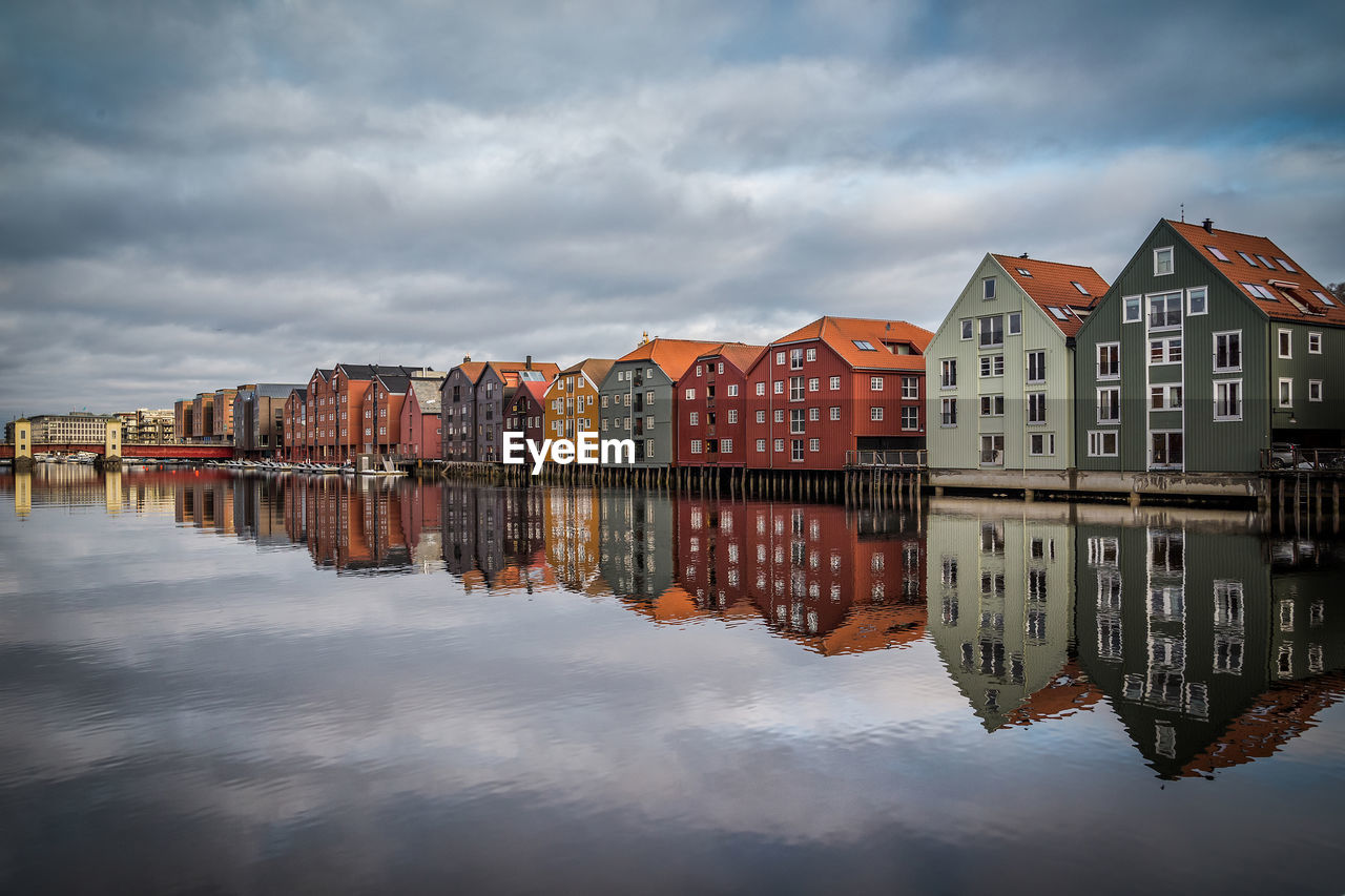 Reflection of houses in water against sky