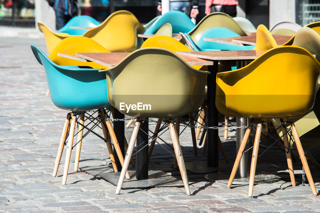 A summer street cafe in city center of tallin with multi colored plastic chairs as outdoor seating
