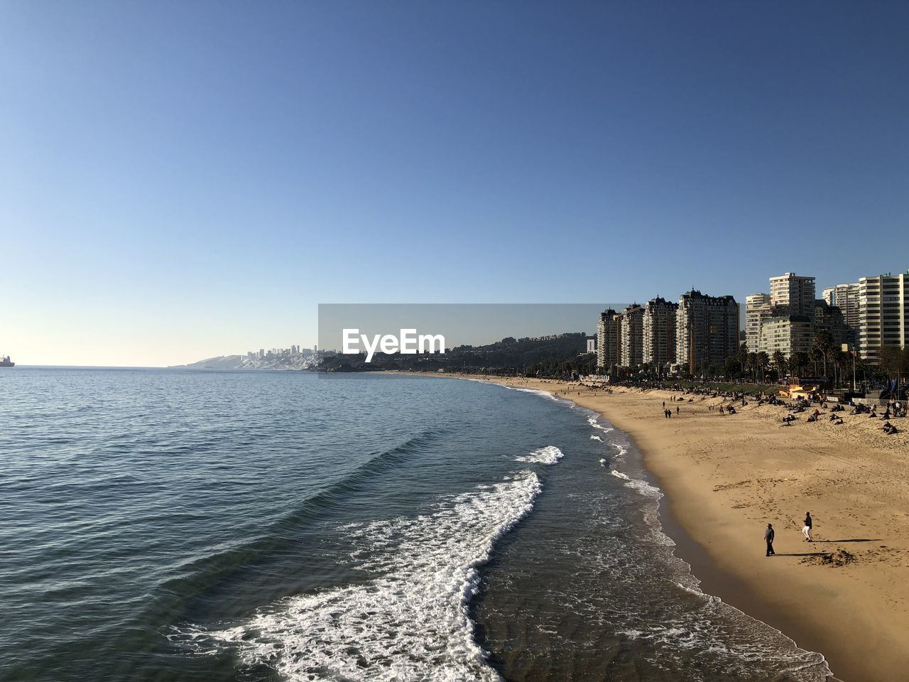 Scenic view of beach against clear sky in city