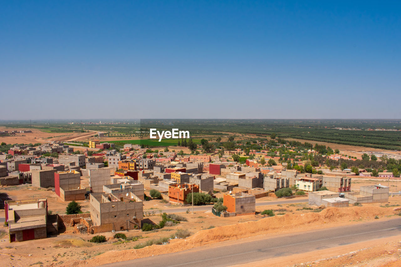 Buildings in city against clear blue sky