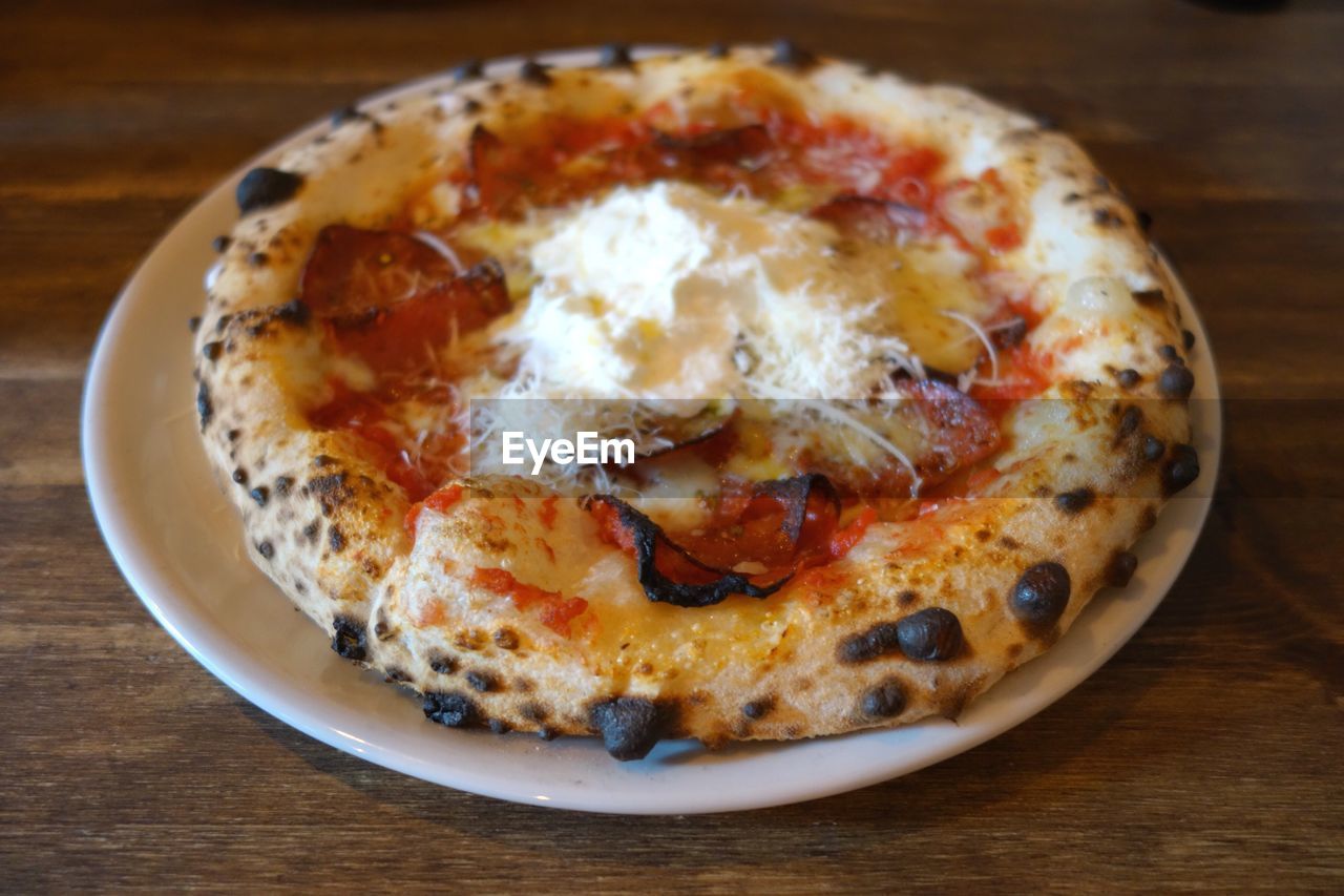 Close-up of pizza in plate on wooden table