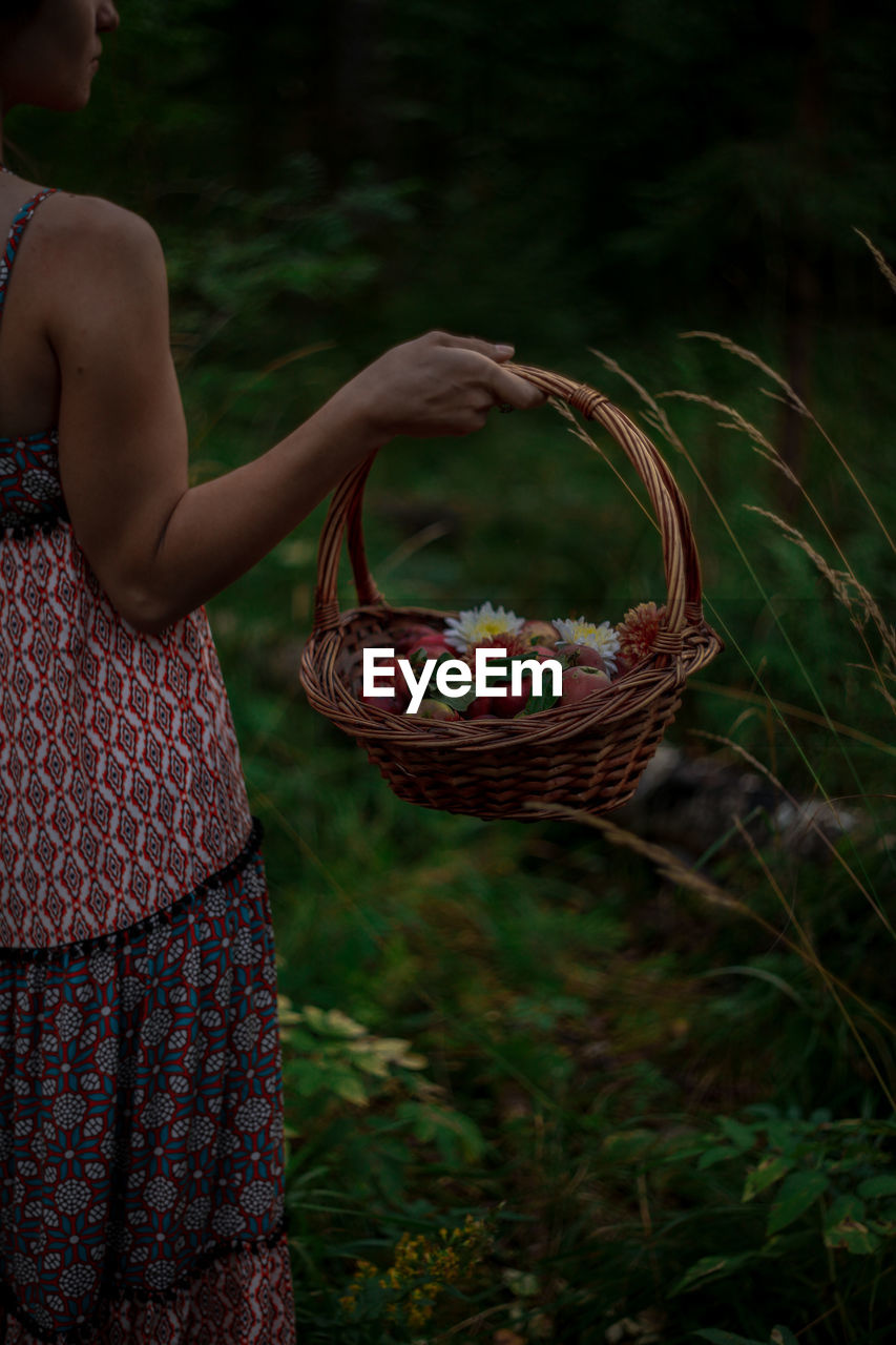 Midsection of woman holding ice cream in basket