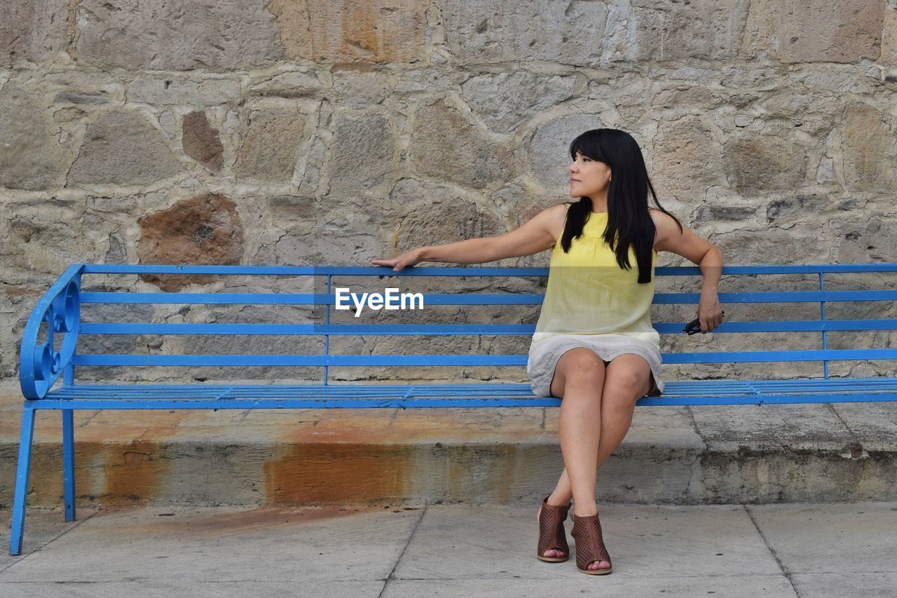 WOMAN STANDING AGAINST WALL