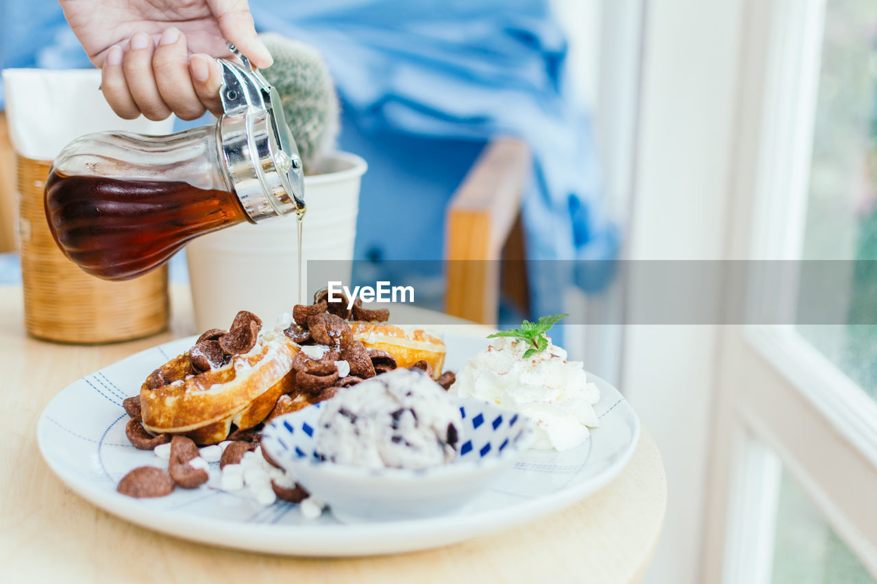 Close-up of syrup pouring on dessert