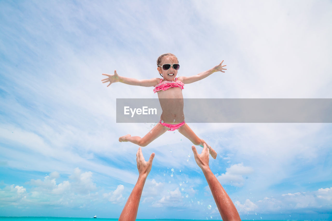 Low angle view of girl in mid air against sky