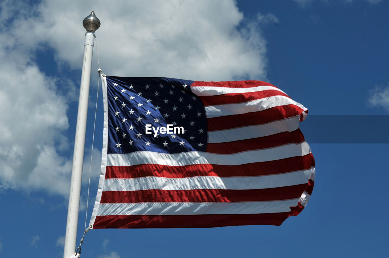 Low angle view of flag against blue sky