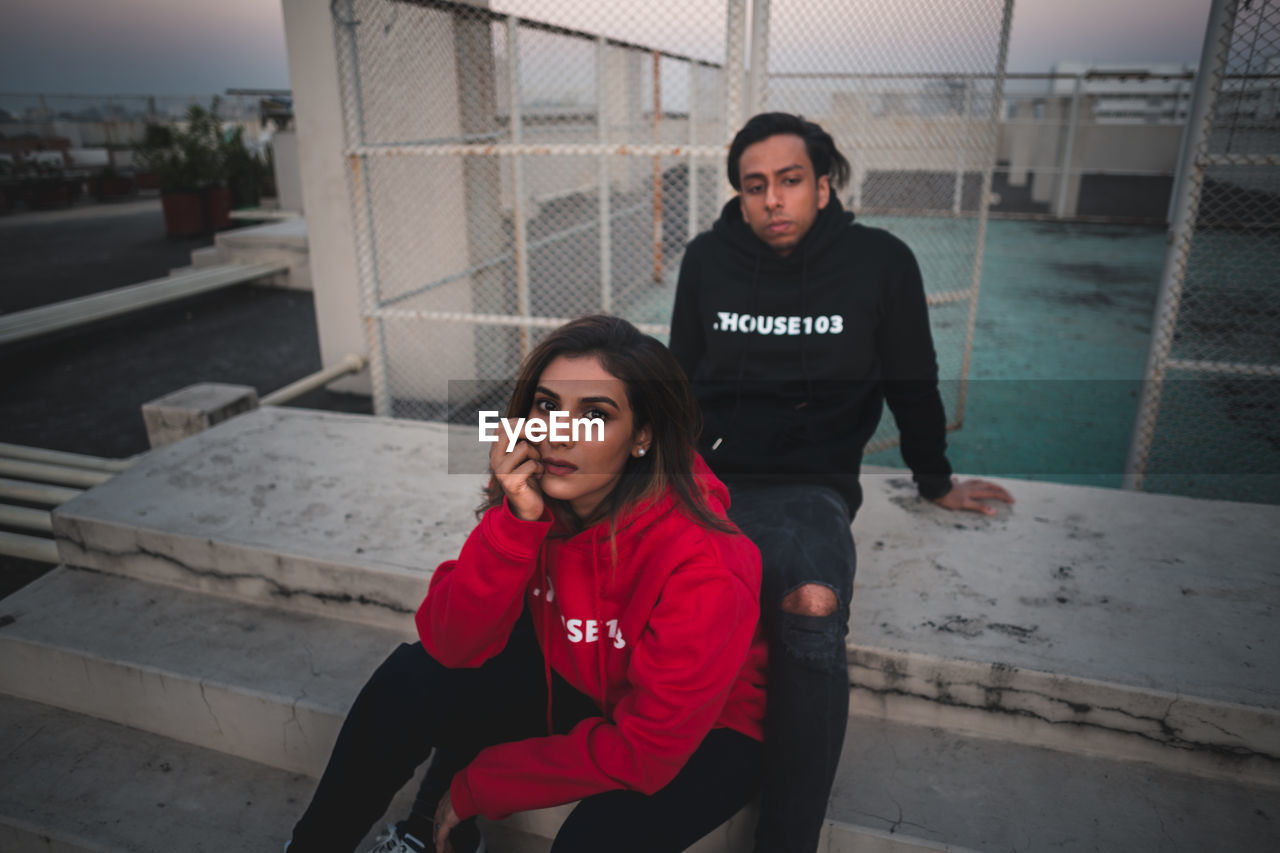 Portrait of young couple sitting outdoors