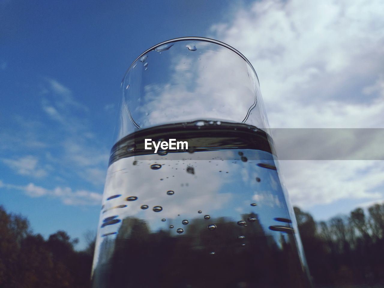 LOW ANGLE VIEW OF GLASS OF BUILDING AGAINST SKY