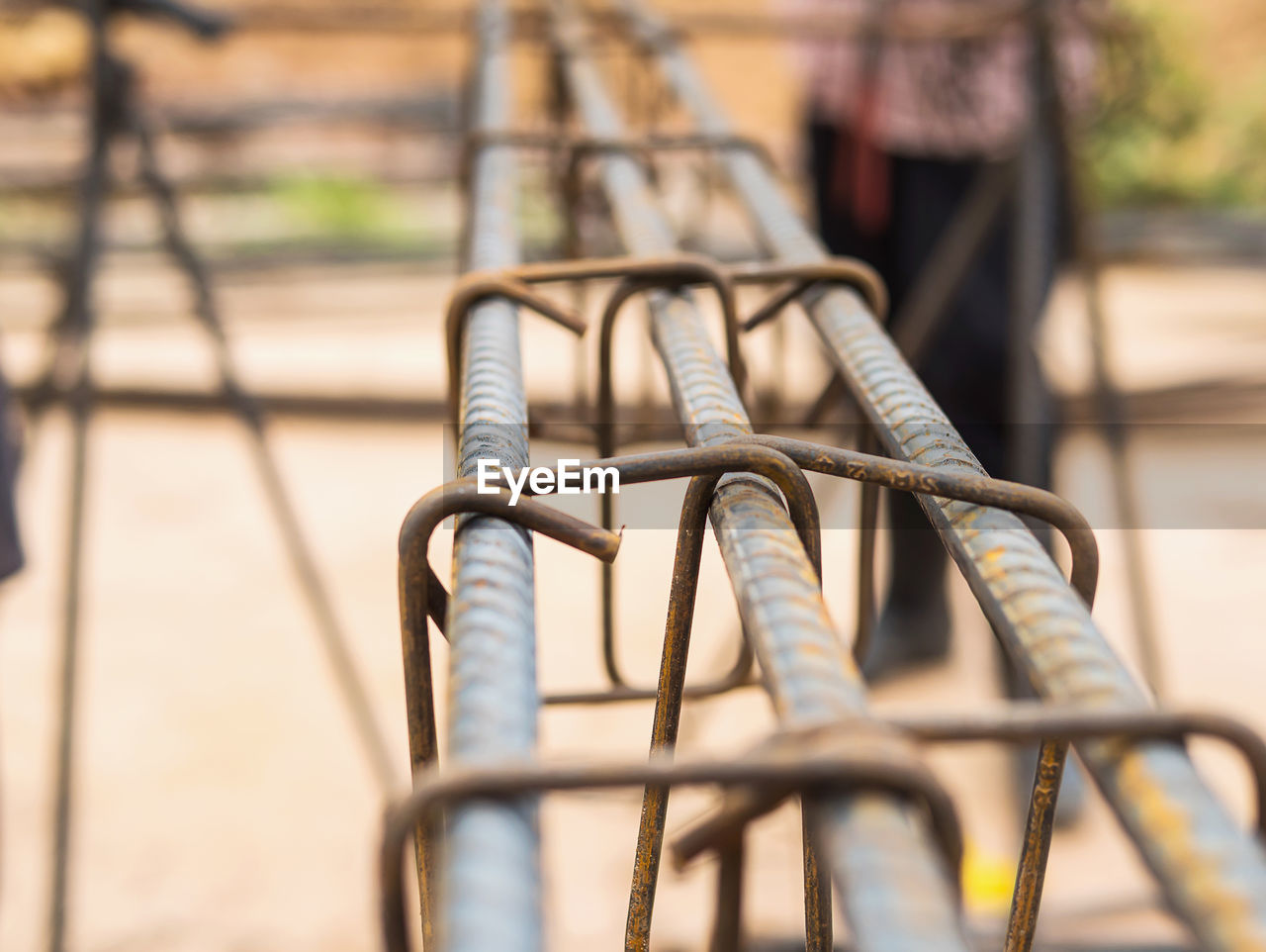 CLOSE-UP OF EMPTY CHAIRS ON RAILING AGAINST PLAYGROUND