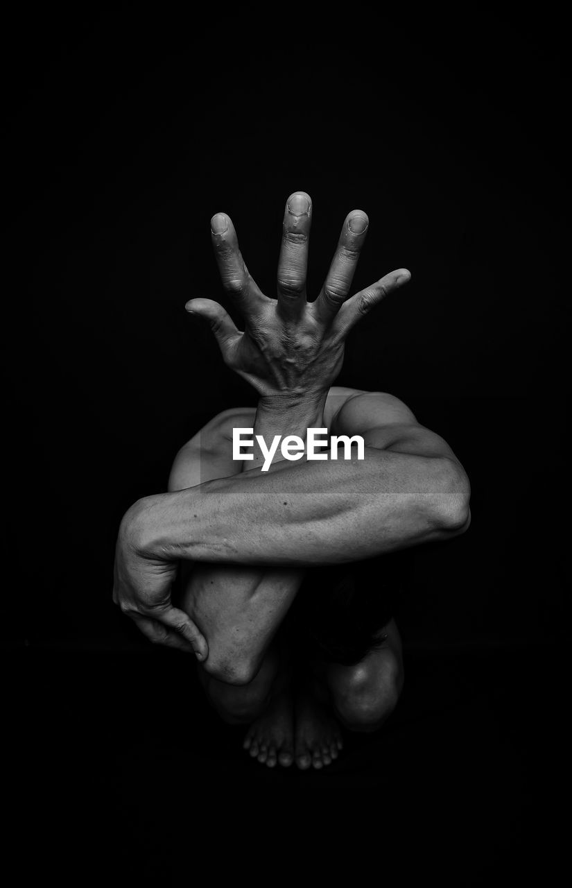 Close-up of human hand against black background