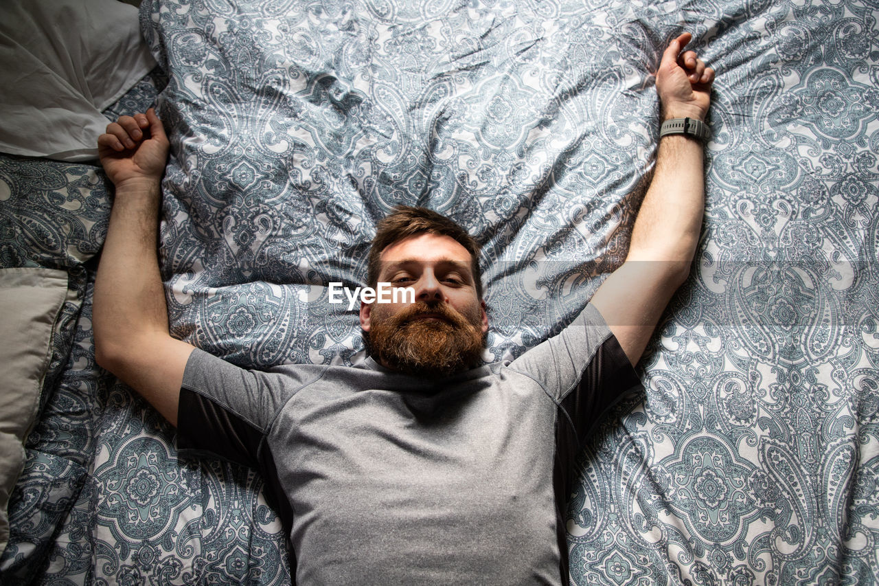 High angle portrait of man lying on bed