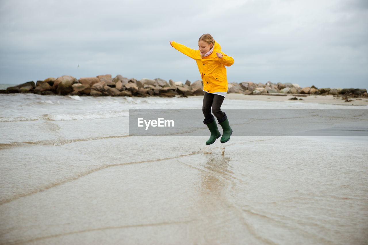 Full length of girl jumping at beach