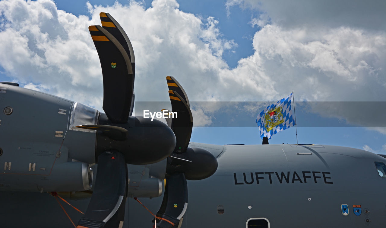 AIRPLANE FLYING IN SKY OVER VEHICLE