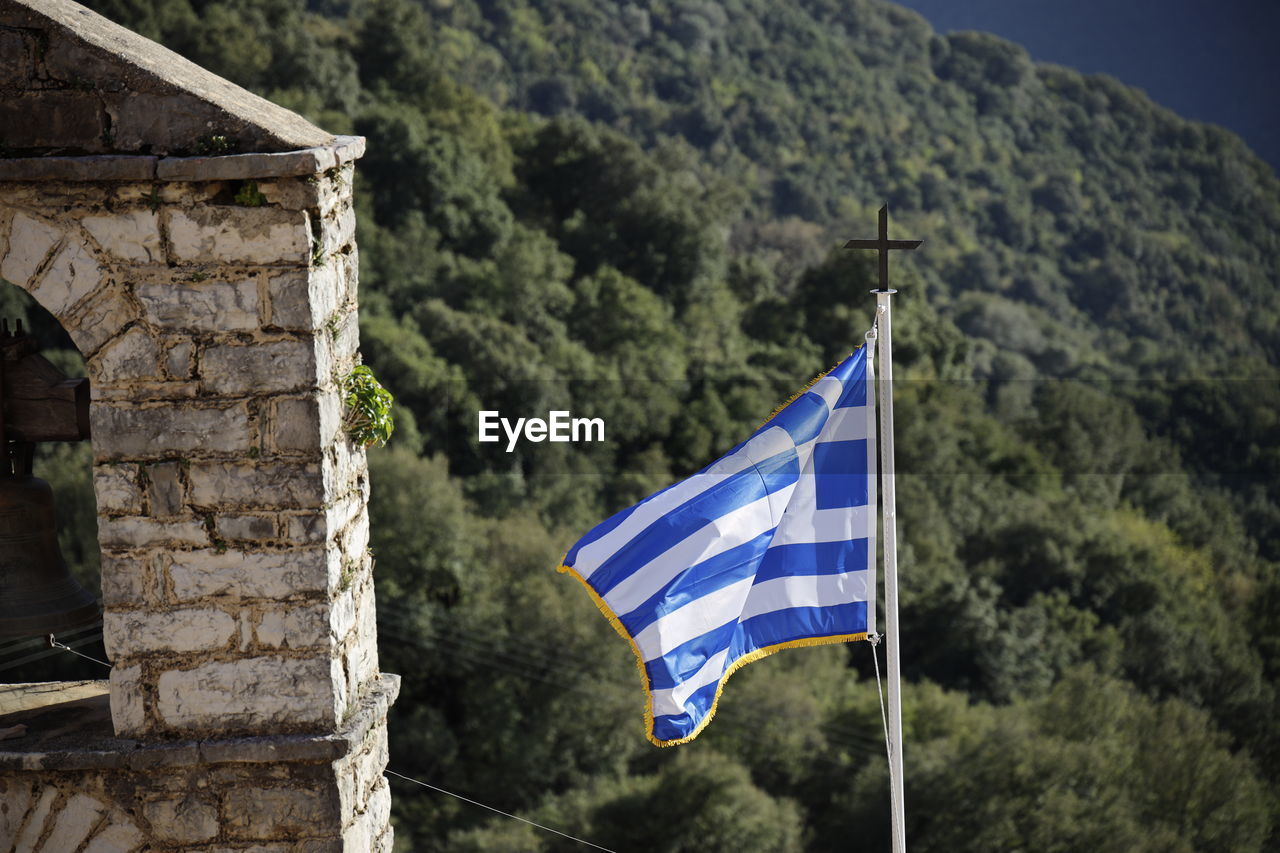 Low angle view of greek flag against mountain