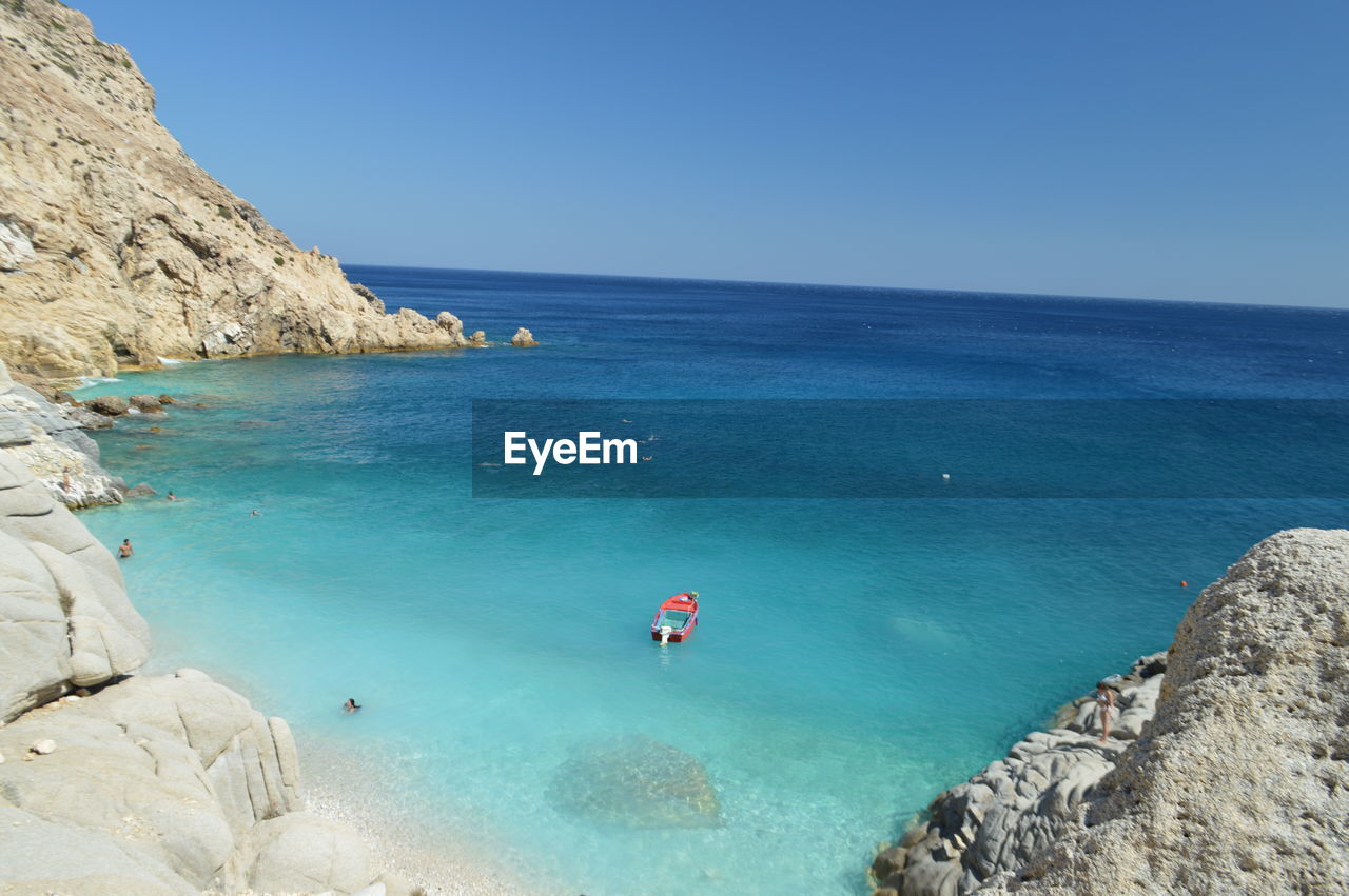 High angle view of red boat in blue sea against clear sky on sunny day