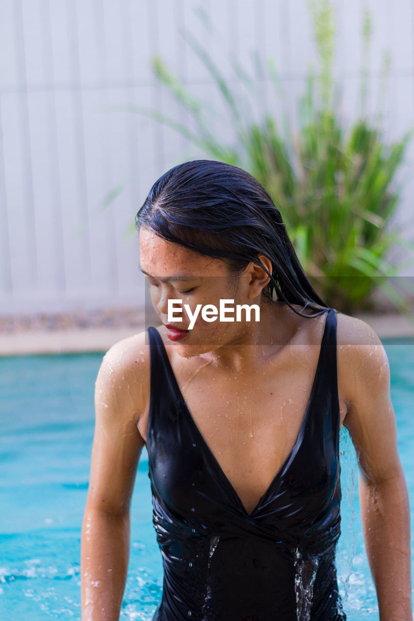 Close up view of sensuous asian woman standing in pool