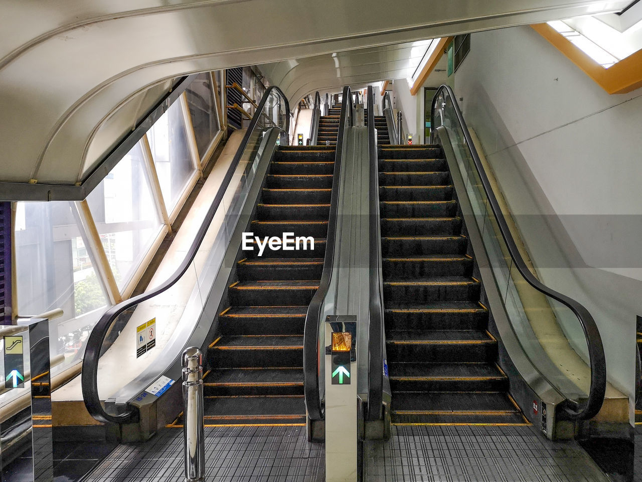 HIGH ANGLE VIEW OF ESCALATOR IN ILLUMINATED UNDERGROUND