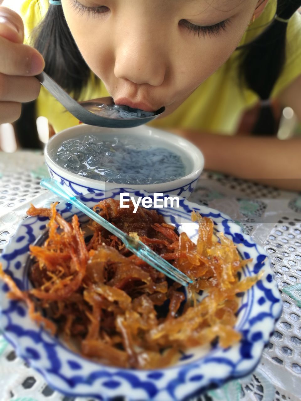 Close-up of girl eating food served on table