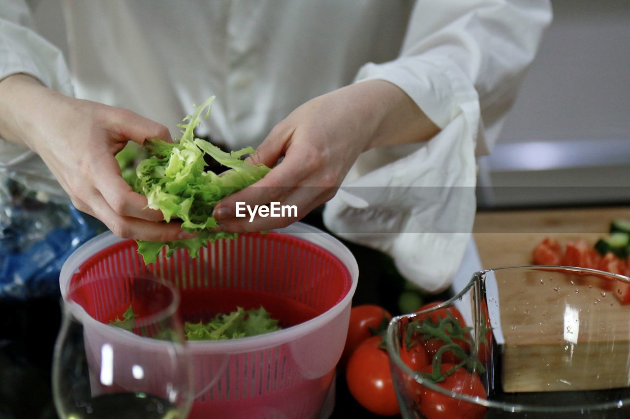 MIDSECTION OF MAN EATING FOOD IN KITCHEN