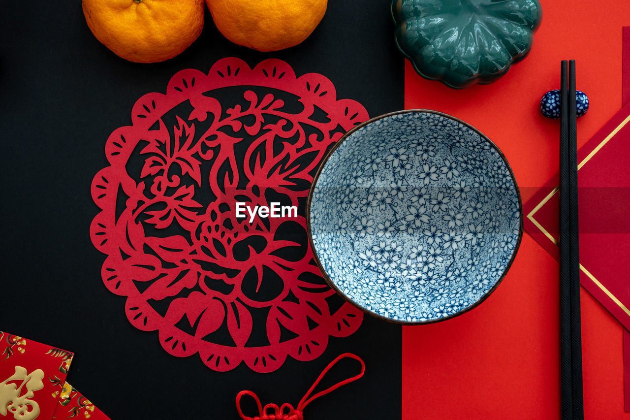 Chinese lunar new year decoration over red and black background. flat lay dinning table concept.